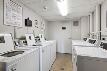 A row of washing machines are lined up in a laundromat.